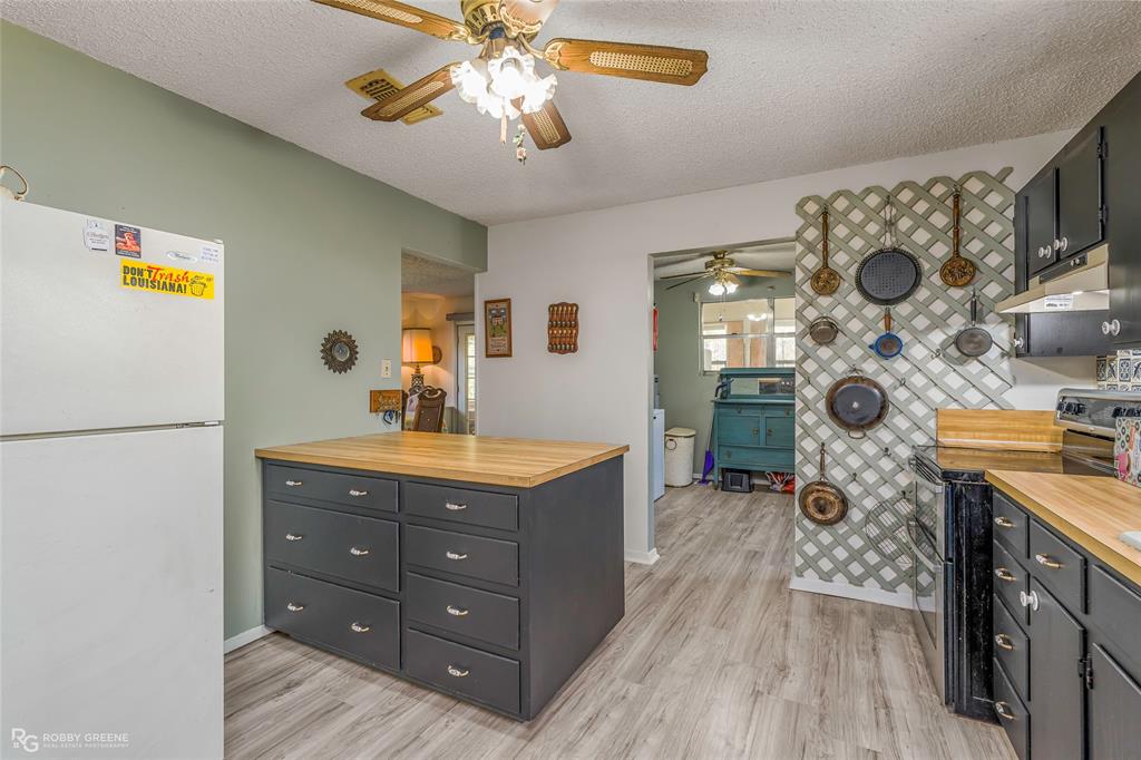 251 Tom Murphy Road Jamestown, LA 71045 - Photo 23 of 40 Kitchen with freestanding refrigerator, range with two ovens, wood counters, a textured ceiling, and dark cabinetry