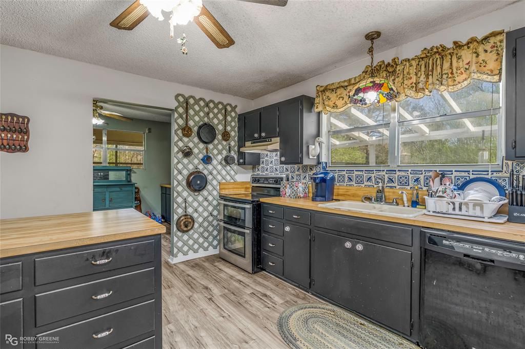 251 Tom Murphy Road Jamestown, LA 71045 - Photo 24 of 40 Kitchen with black dishwasher, range with two ovens, decorative backsplash, light wood-style floors, and wooden counters
