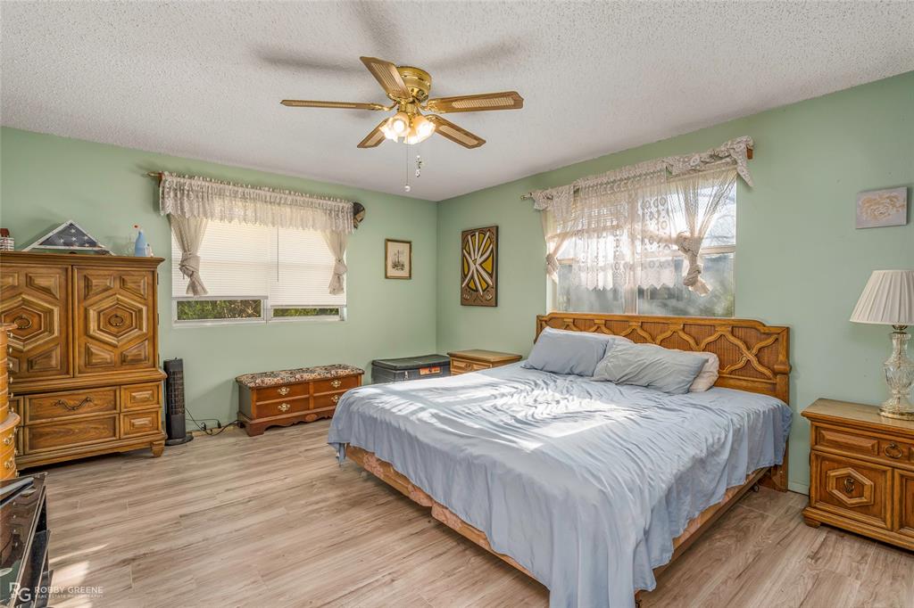 251 Tom Murphy Road Jamestown, LA 71045 - Photo 27 of 40 Bedroom with light wood-type flooring, multiple windows, a ceiling fan, and a textured ceiling