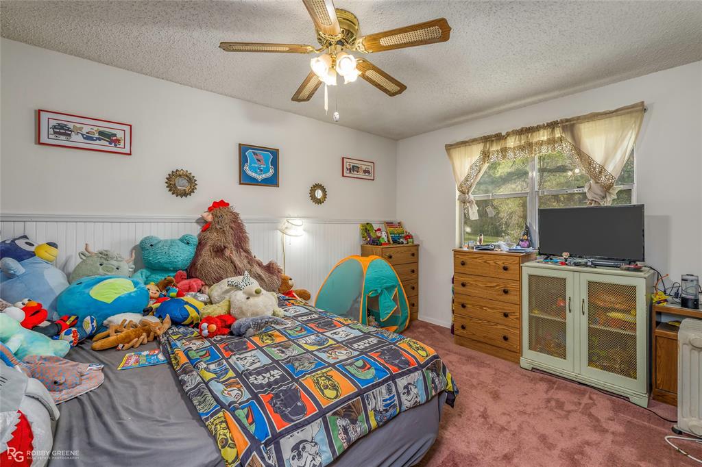 251 Tom Murphy Road Jamestown, LA 71045 - Photo 35 of 40 Carpeted bedroom with a textured ceiling, ceiling fan, and wainscoting