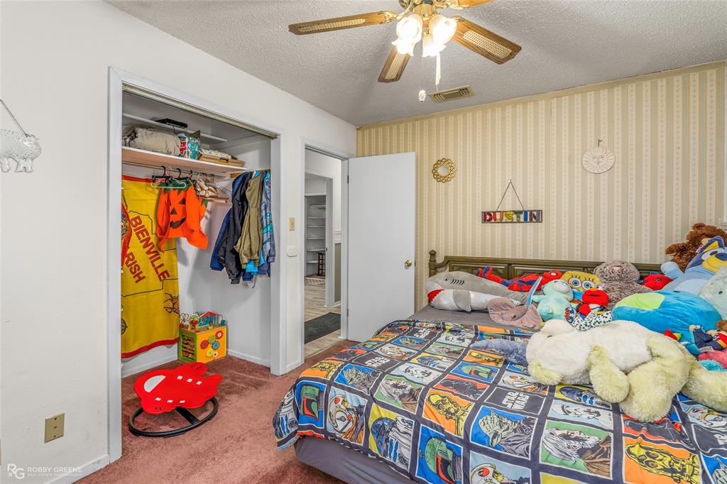 251 Tom Murphy Road Jamestown, LA 71045 - Photo 36 of 40 Bedroom with carpet flooring, wallpapered walls, a ceiling fan, a textured ceiling, and a closet