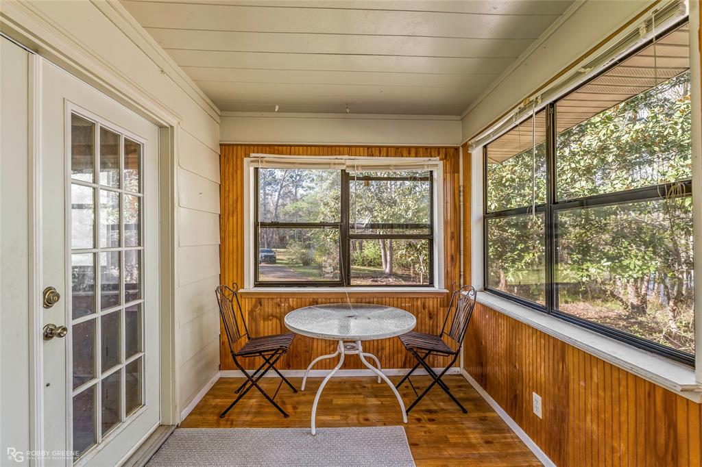 251 Tom Murphy Road Jamestown, LA 71045 - Photo 38 of 40 Sunroom featuring wooden walls, hardwood / wood-style floors, and plenty of natural light