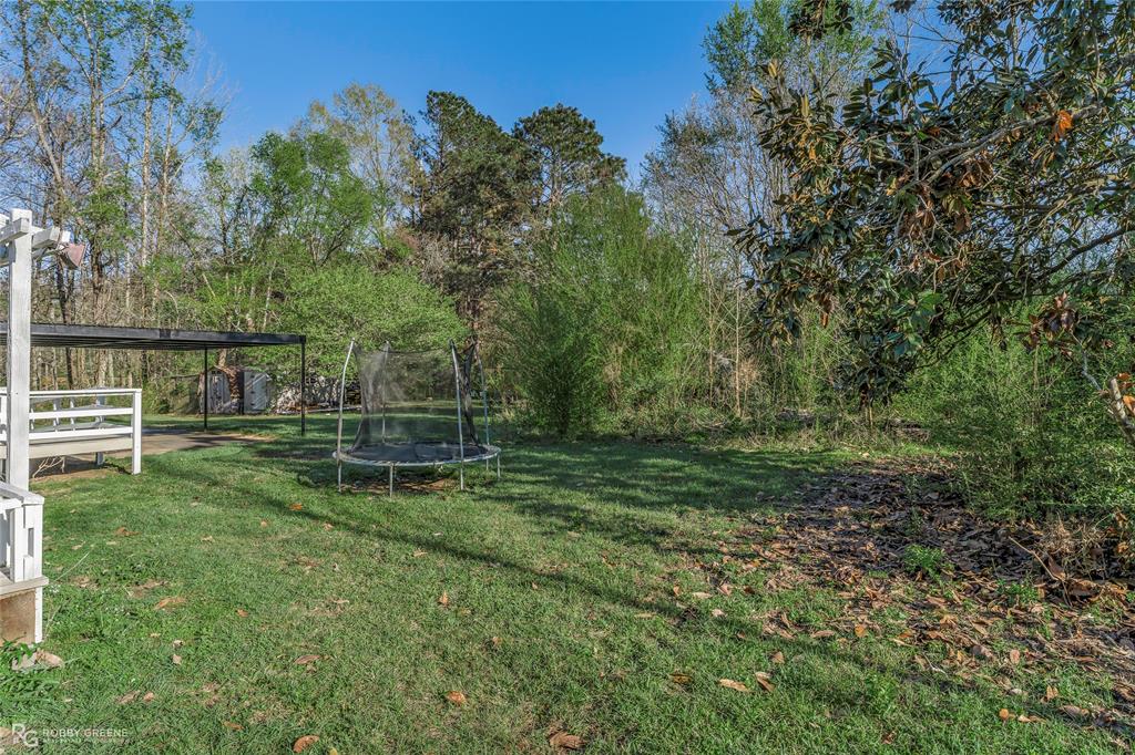 251 Tom Murphy Road Jamestown, LA 71045 - Photo 4 of 40 View of grassy yard featuring a trampoline