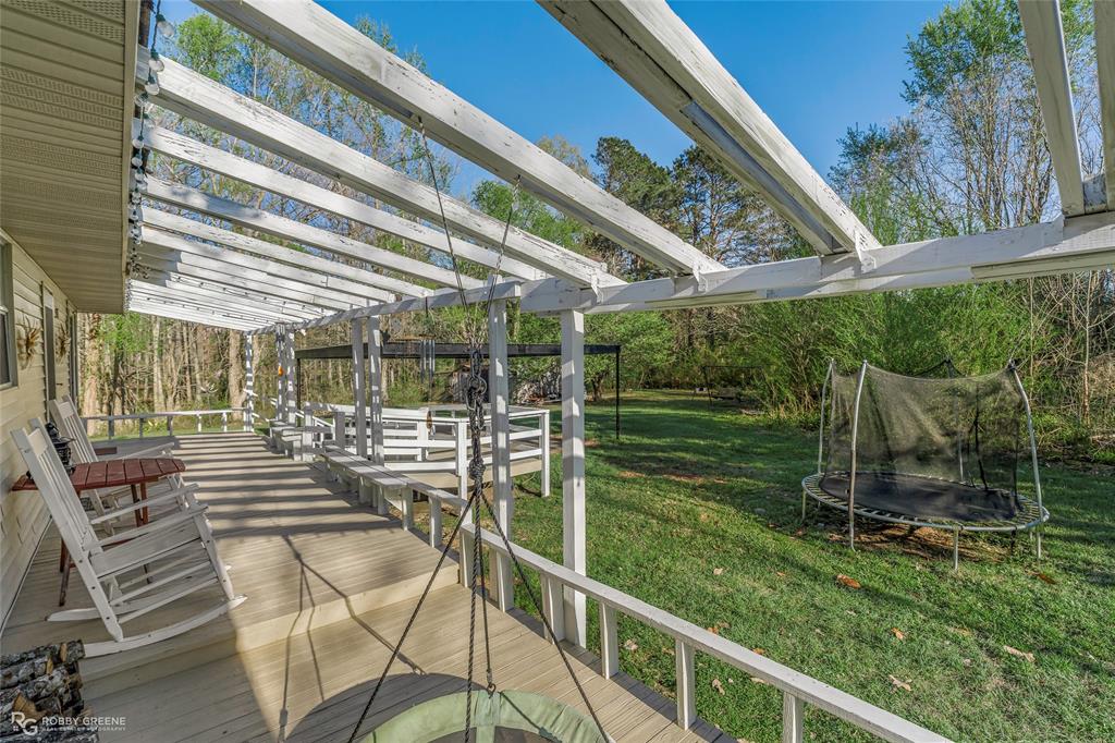 251 Tom Murphy Road Jamestown, LA 71045 - Photo 10 of 40 Wooden deck with a trampoline and a yard