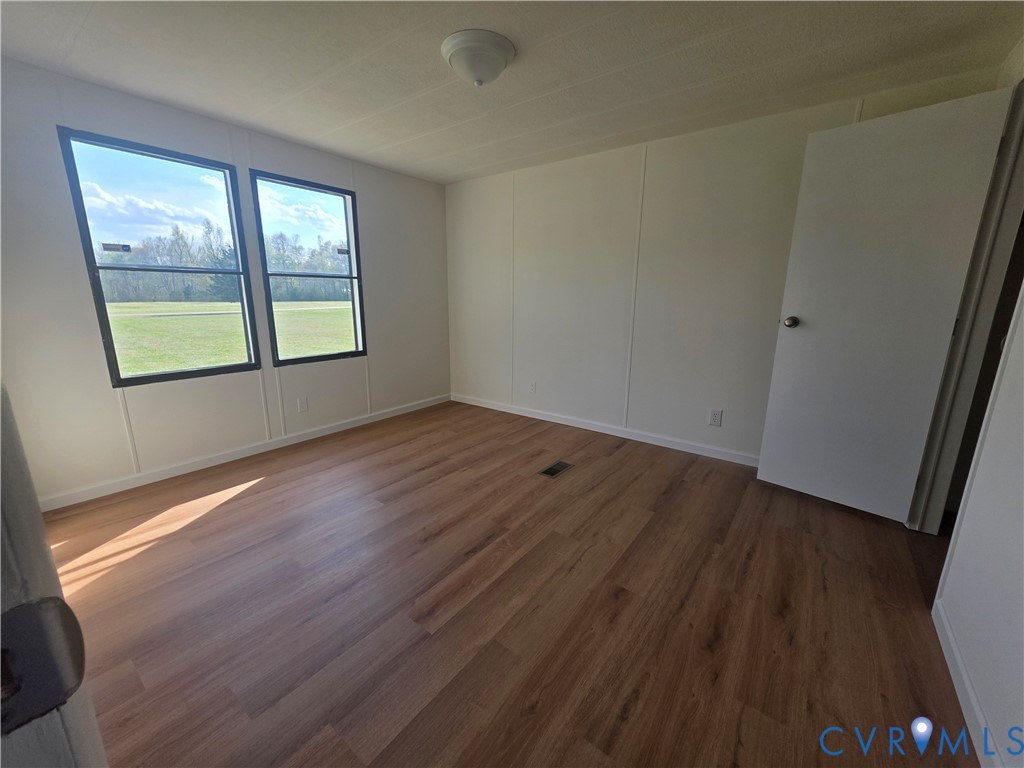 16808 Hamilton Arms Road Dewitt, VA 23840 - Photo 22 of 30 an empty room with wooden floor and windows