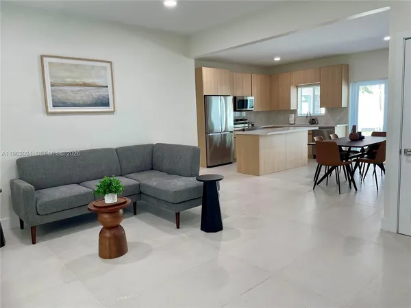 a living room with furniture and kitchen view