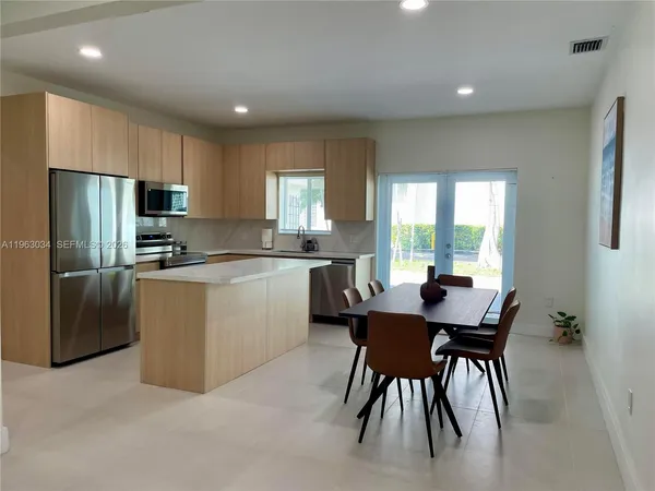 a kitchen with a table chairs refrigerator and microwave