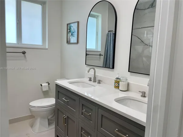 a bathroom with a toilet a sink and mirror