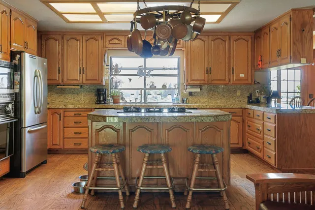 a kitchen with stainless steel appliances kitchen island granite countertop a sink and cabinets