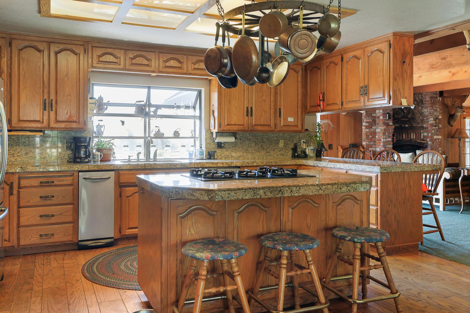 22050 Buena Vista Road Clements, CA 95227 - Photo 16 of 61 a kitchen with stainless steel appliances granite countertop a stove a sink and white cabinets with wooden floor