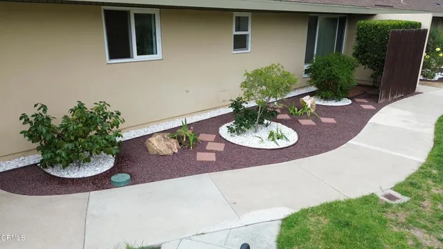 a view of a backyard with chair and potted plants