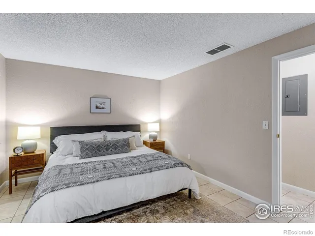 a bedroom with a large bed and a lamp with window