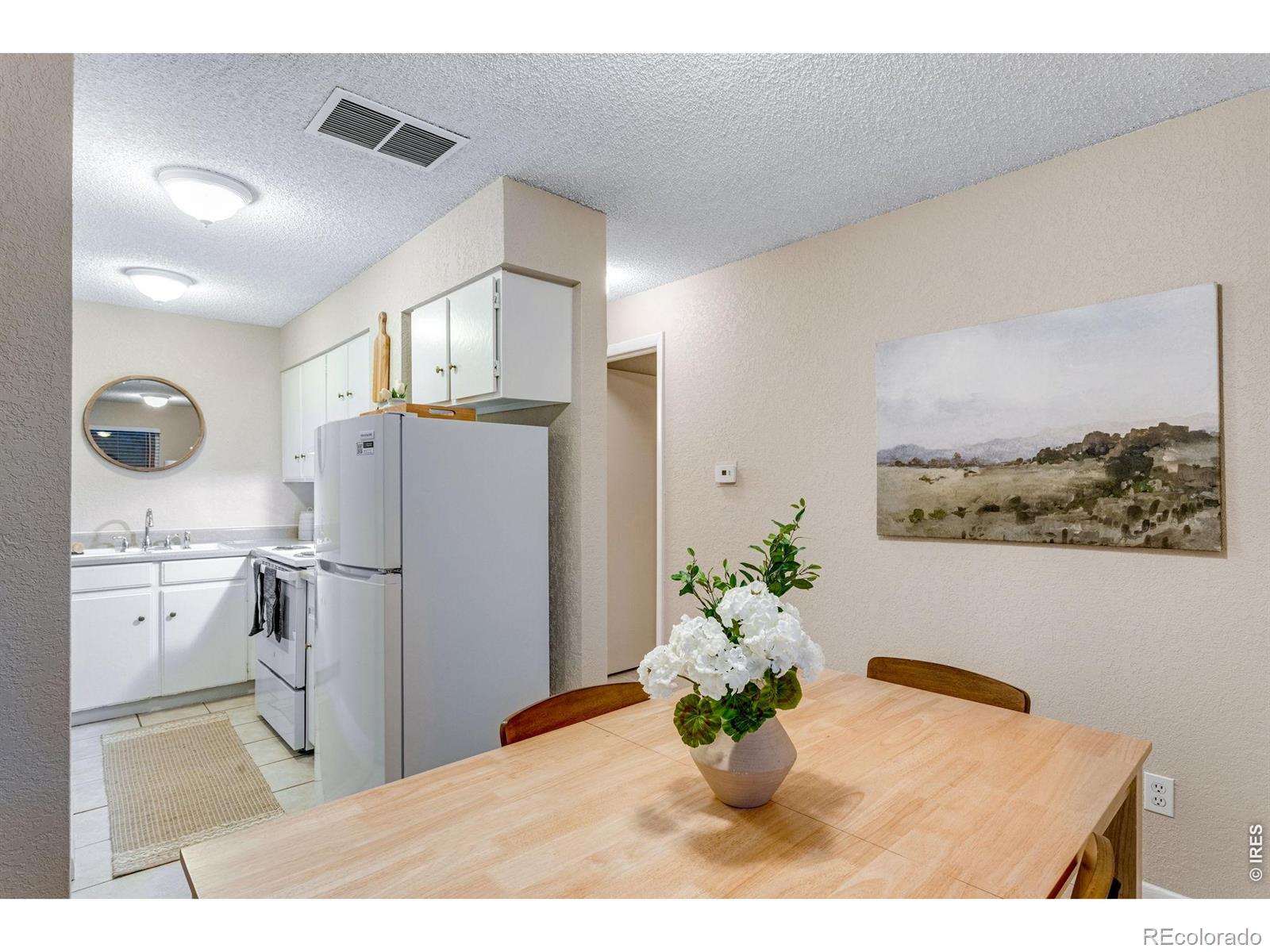 1705 Heatheridge Road Fort Collins, CO 80526 - Photo 8 of 21 a kitchen with stainless steel appliances kitchen island granite countertop a refrigerator a stove a microwave oven with white cabinets and wooden floor