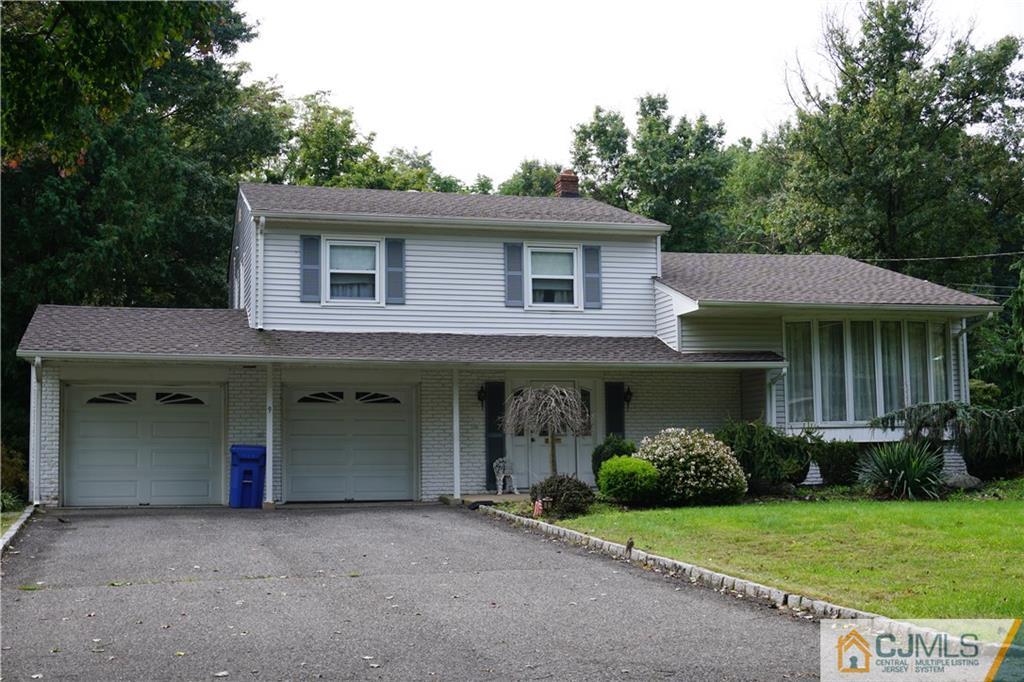 9 Ravine Drive Colonia, NJ 07067 - Photo 1 of 2 a front view of a house with a garden and plants
