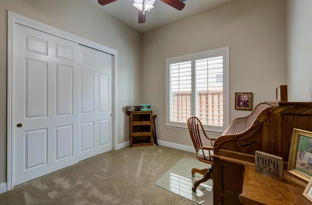 a view of a workspace with furniture and a window