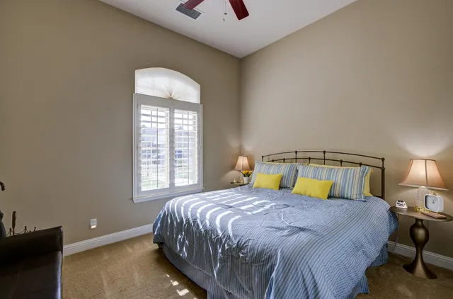 a bed sitting in a bedroom next to a window