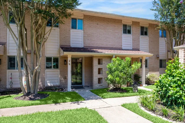 a front view of a house with a yard and potted plants
