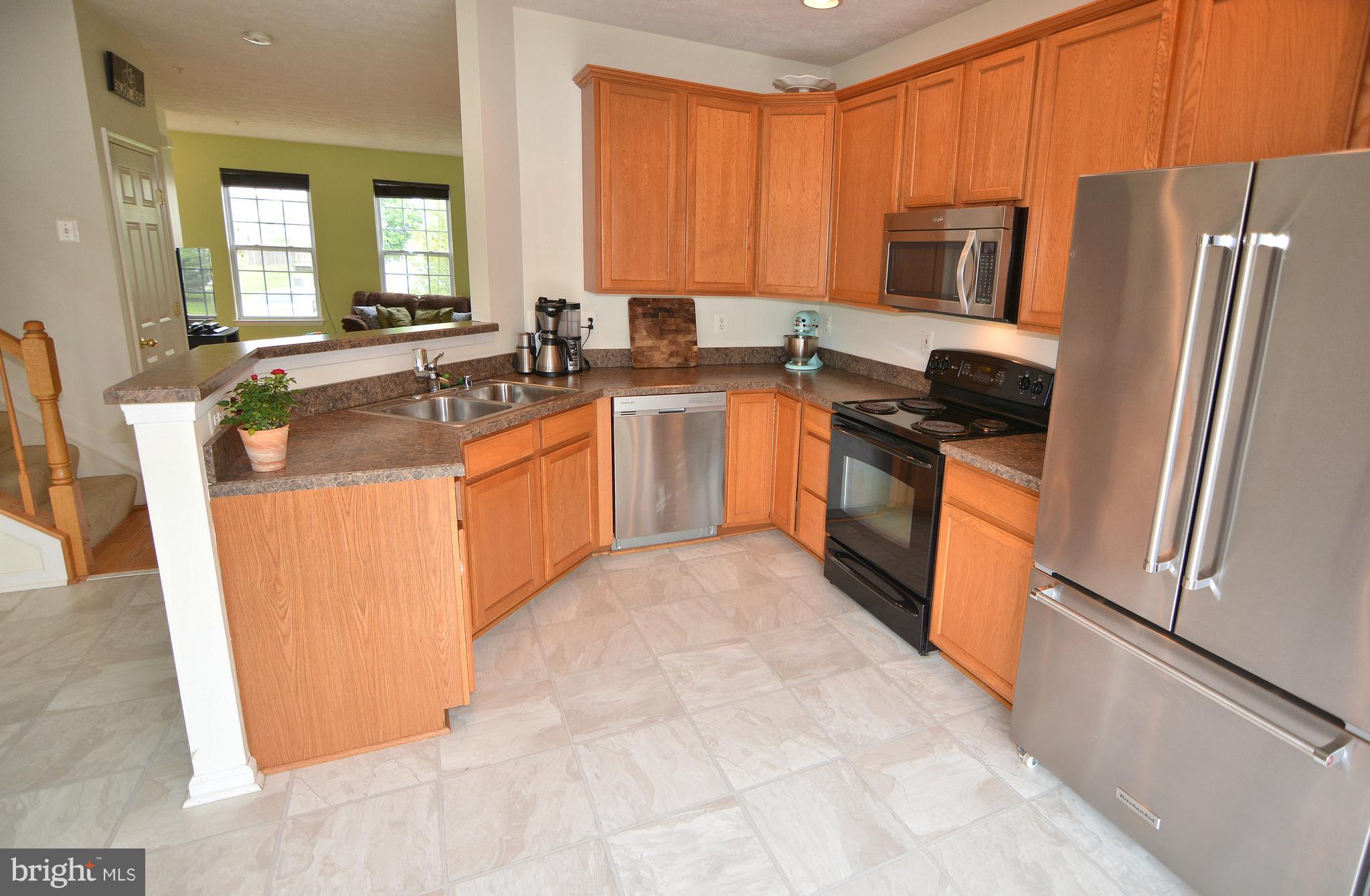 9722 Langley Road Baltimore, MD 21220 - Photo 2 of 30 a large kitchen with stainless steel appliances granite countertop a refrigerator stove a sink dishwasher and microwave