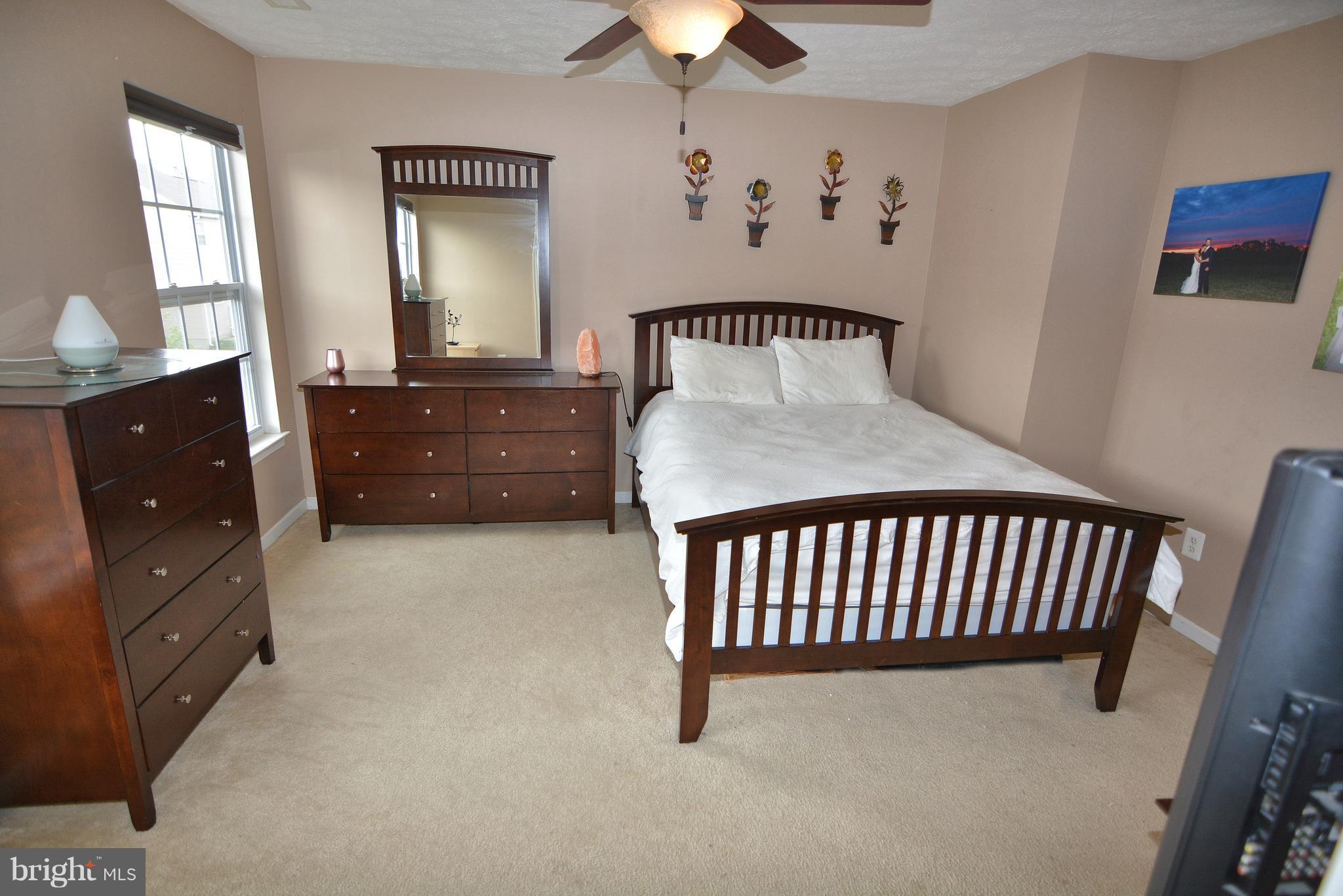 9722 Langley Road Baltimore, MD 21220 - Photo 11 of 30 a bedroom with a bed and a chandelier