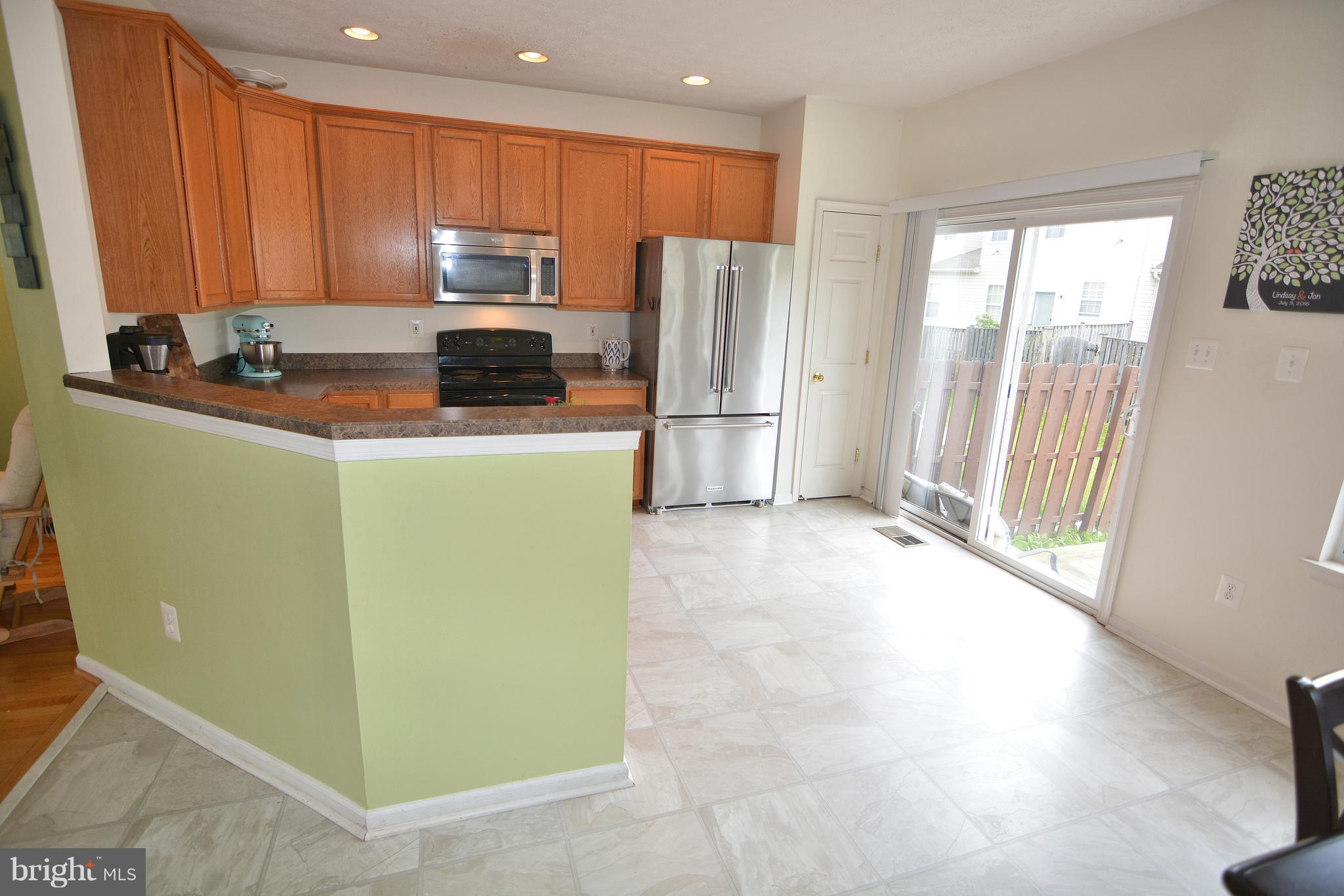 9722 Langley Road Baltimore, MD 21220 - Photo 28 of 30 a kitchen with a refrigerator a stove and a cabinets