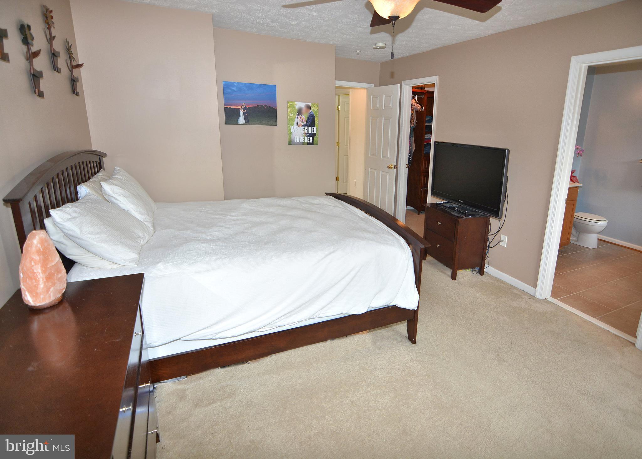 9722 Langley Road Baltimore, MD 21220 - Photo 29 of 30 a bedroom with a bed and a chandelier