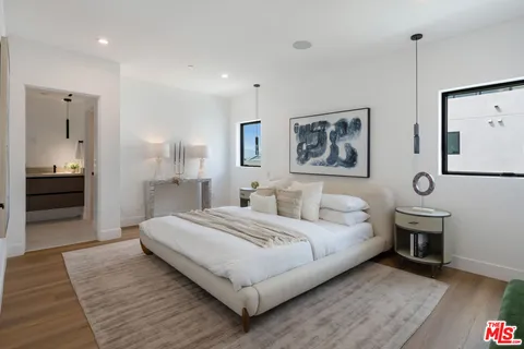 a spacious bedroom with a bed and a chandelier