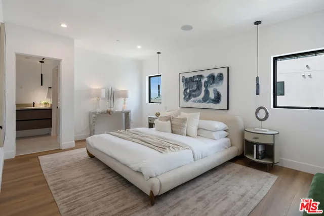 a spacious bedroom with a bed and a chandelier