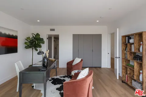 a living room with furniture a bookshelf and a potted plant