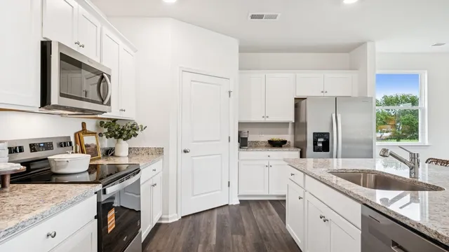 a kitchen with a sink stove top oven and refrigerator