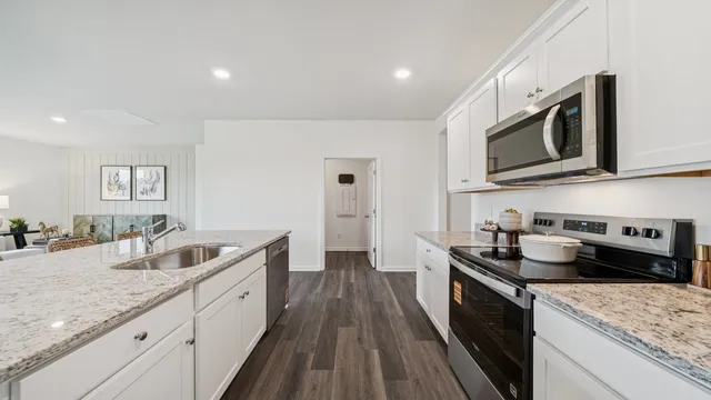 a kitchen with stainless steel appliances granite countertop a sink stove and cabinets