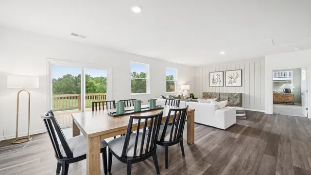 a view of a dining room with furniture large windows and wooden floor