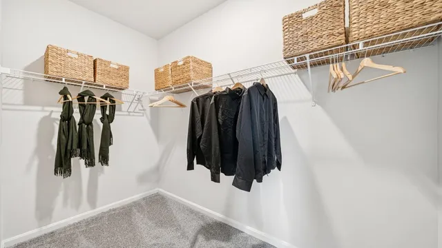 a view of walk in closet with clothes and shoes