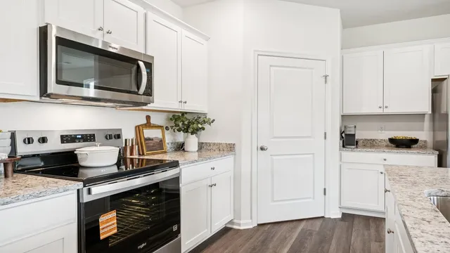 a kitchen with stainless steel appliances granite countertop a stove a microwave and cabinets