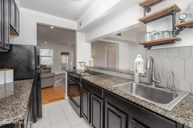 a kitchen with granite countertop stainless steel appliances a sink stove and cabinets