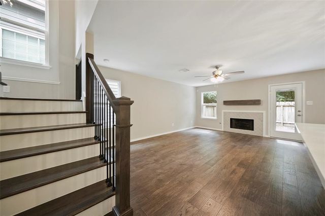 a view of empty room with fireplace and wooden floor