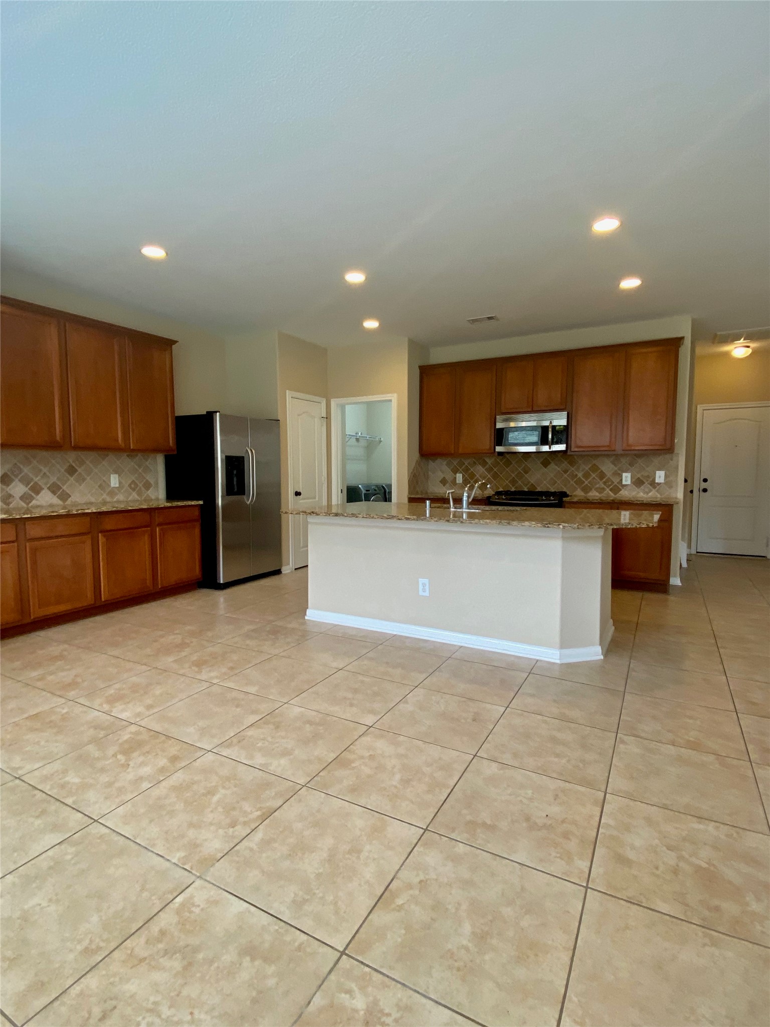 15 Sagamore Ridge Place The Woodlands, TX 77389 - Photo 14 of 39 a view of kitchen with stainless steel appliances granite countertop a refrigerator and a stove top oven