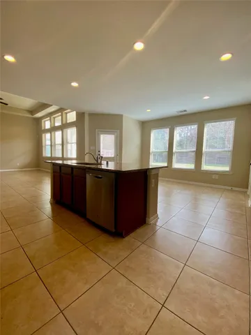 a kitchen with kitchen island granite countertop a stove a sink a microwave a refrigerator and cabinets