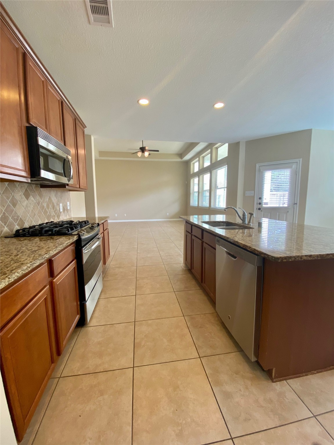 15 Sagamore Ridge Place The Woodlands, TX 77389 - Photo 17 of 39 a large kitchen with stainless steel appliances granite countertop a stove a sink and a microwave