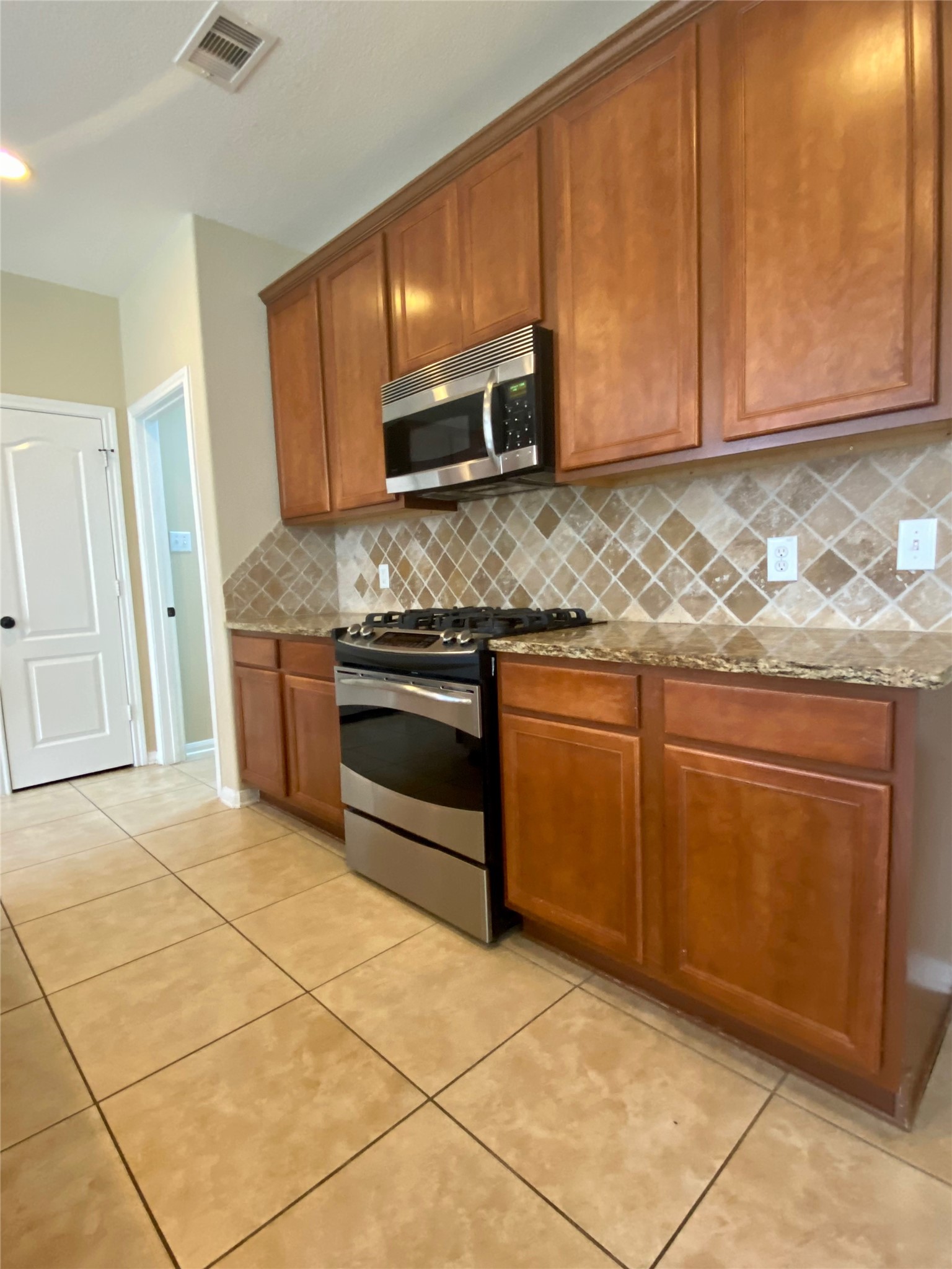 15 Sagamore Ridge Place The Woodlands, TX 77389 - Photo 19 of 39 a kitchen with stainless steel appliances granite countertop a stove a sink and a microwave