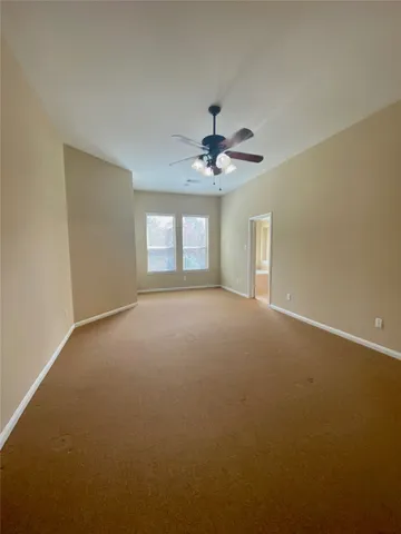 an empty room with a ceiling fan and a window