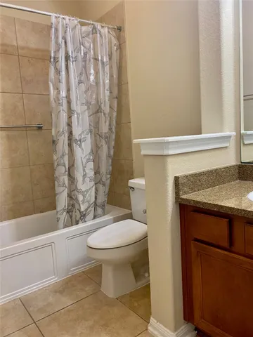 a bathroom with a granite countertop toilet and a sink