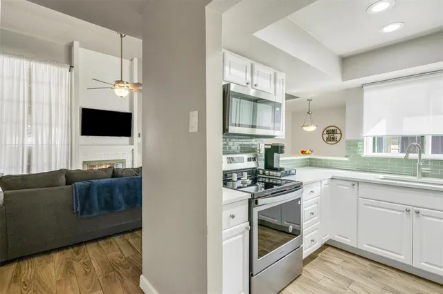a kitchen with stainless steel appliances granite countertop a stove a sink and a microwave