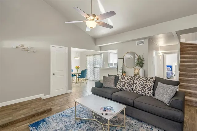 a living room with furniture and a wooden floor