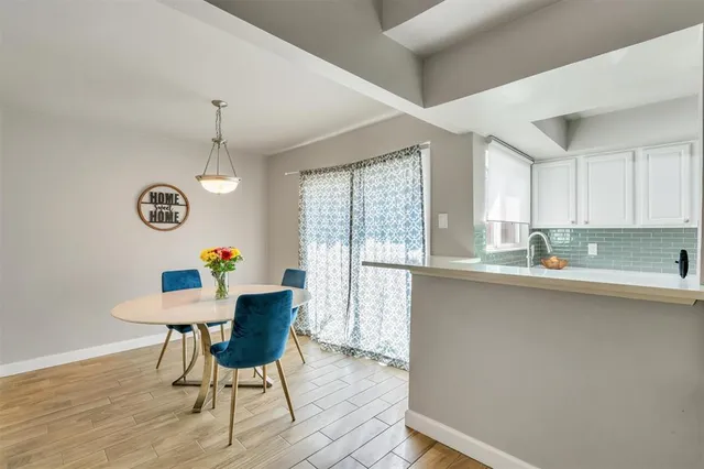 a kitchen with a table chairs a sink dishwasher window and cabinets