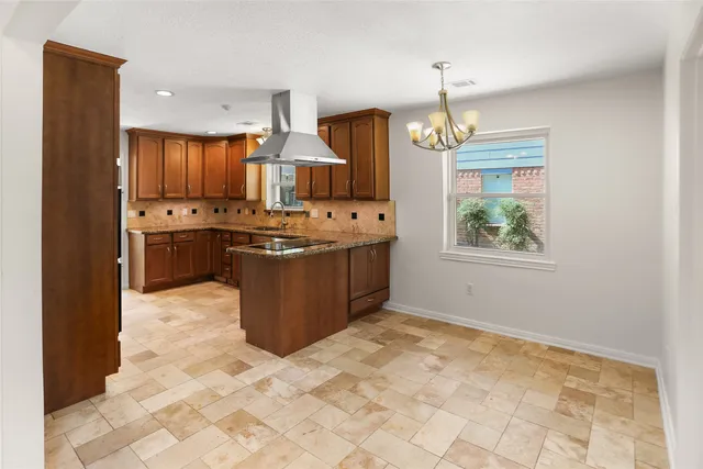 a kitchen with stainless steel appliances granite countertop a stove top oven a refrigerator a sink and dishwasher
