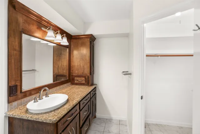 a bathroom with a granite countertop sink and a mirror