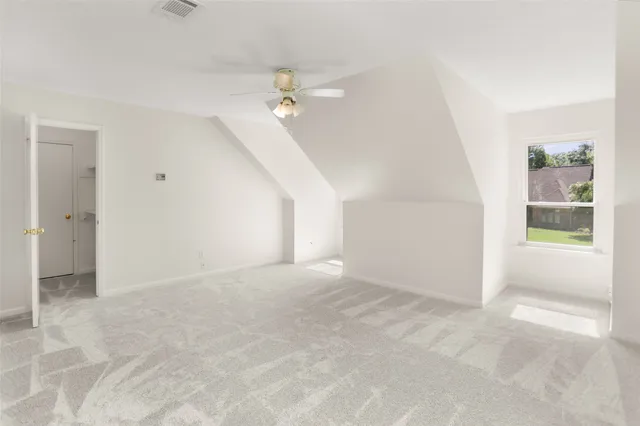 an empty room with fan and windows