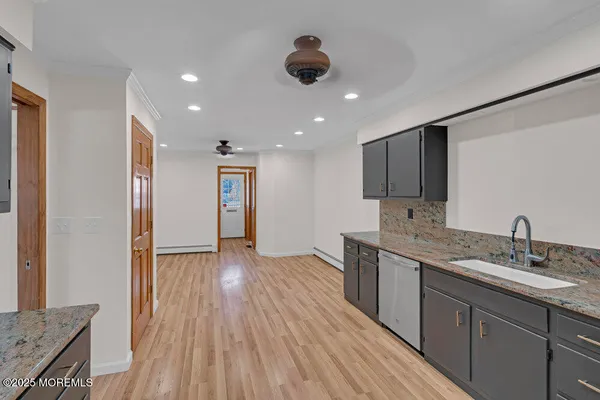 a kitchen with stainless steel appliances granite countertop a sink and wooden floor