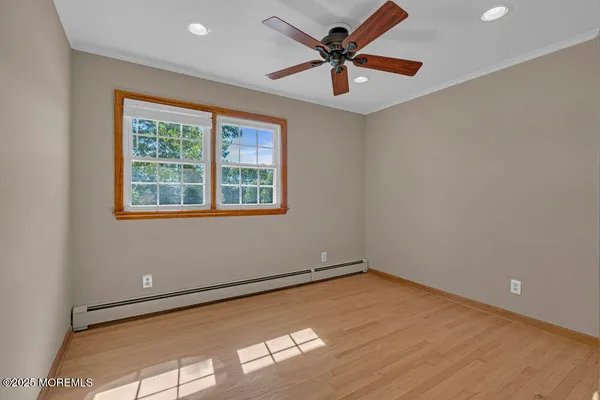 an empty room with a window and a ceiling fan
