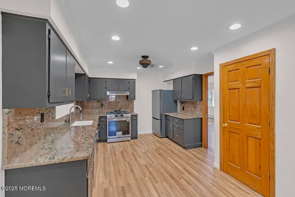 a kitchen with stainless steel appliances granite countertop a refrigerator stove and sink